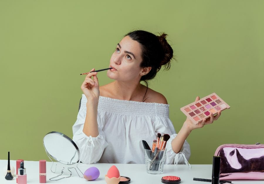 rutina de maquillaje paso a paso con productos sobre tocador